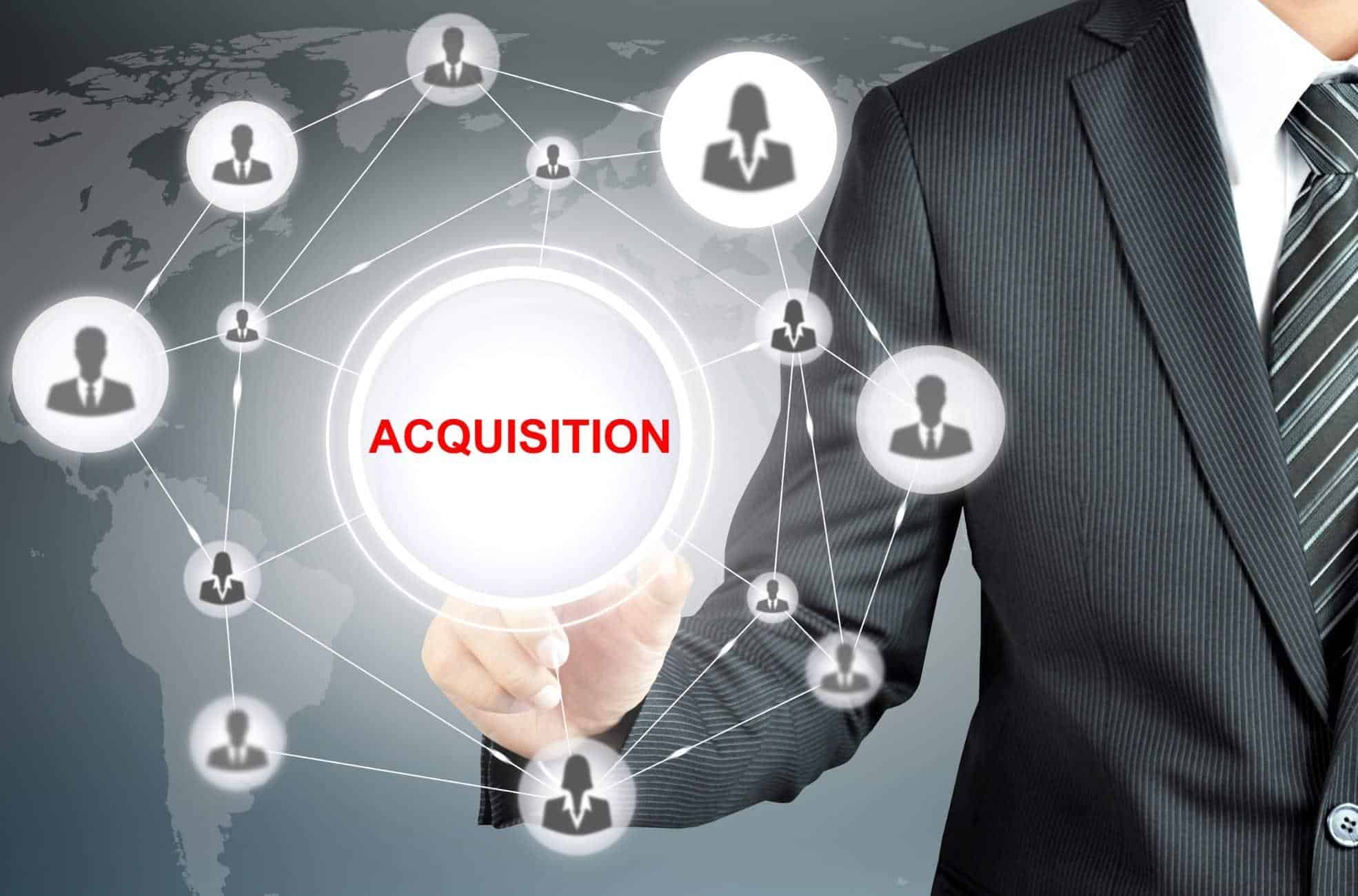 Business Man Pointing To Sign Saying "Acquisition"