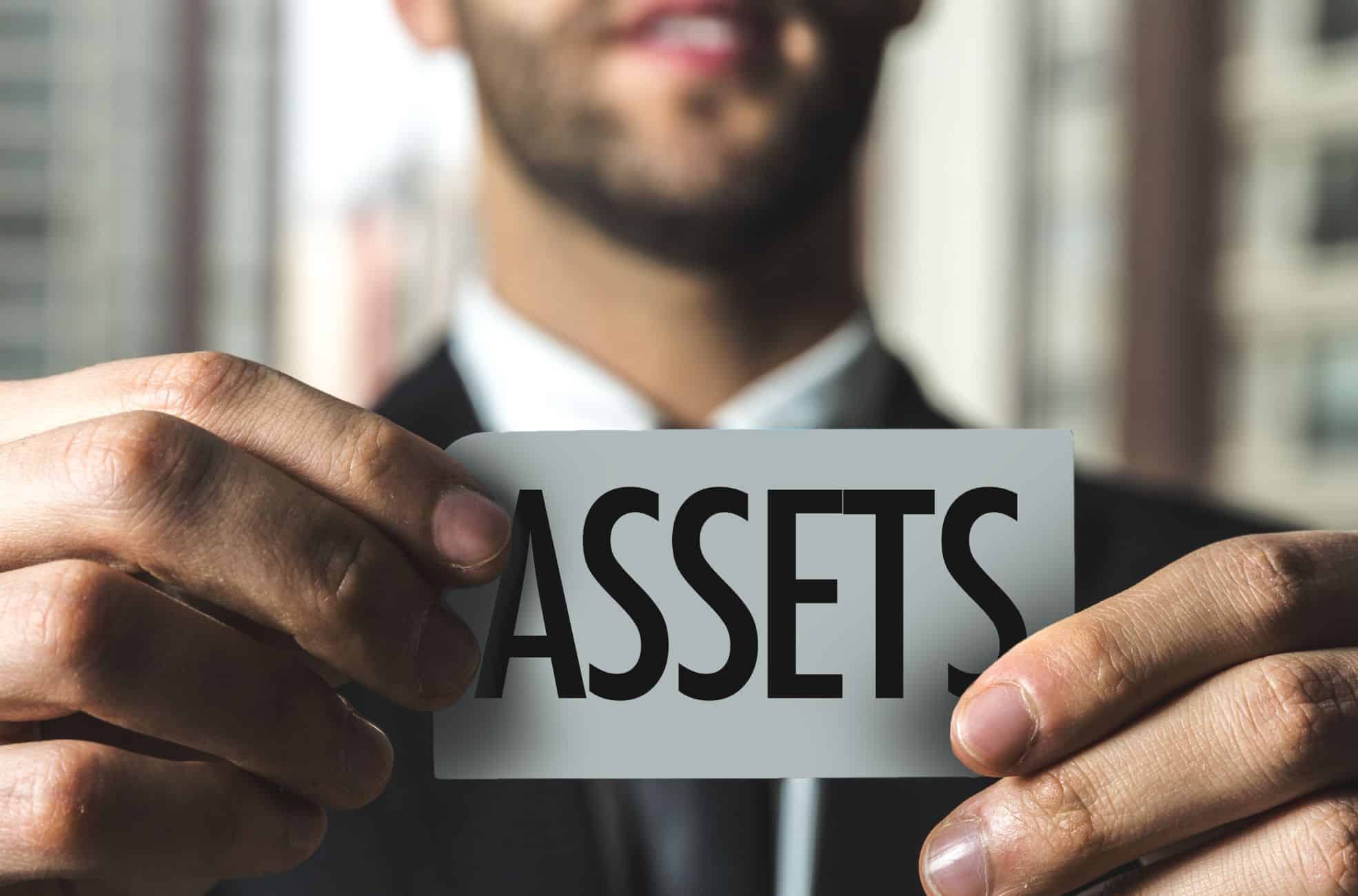 Businessman Holding Sign Saying "Assets" For Depreciation