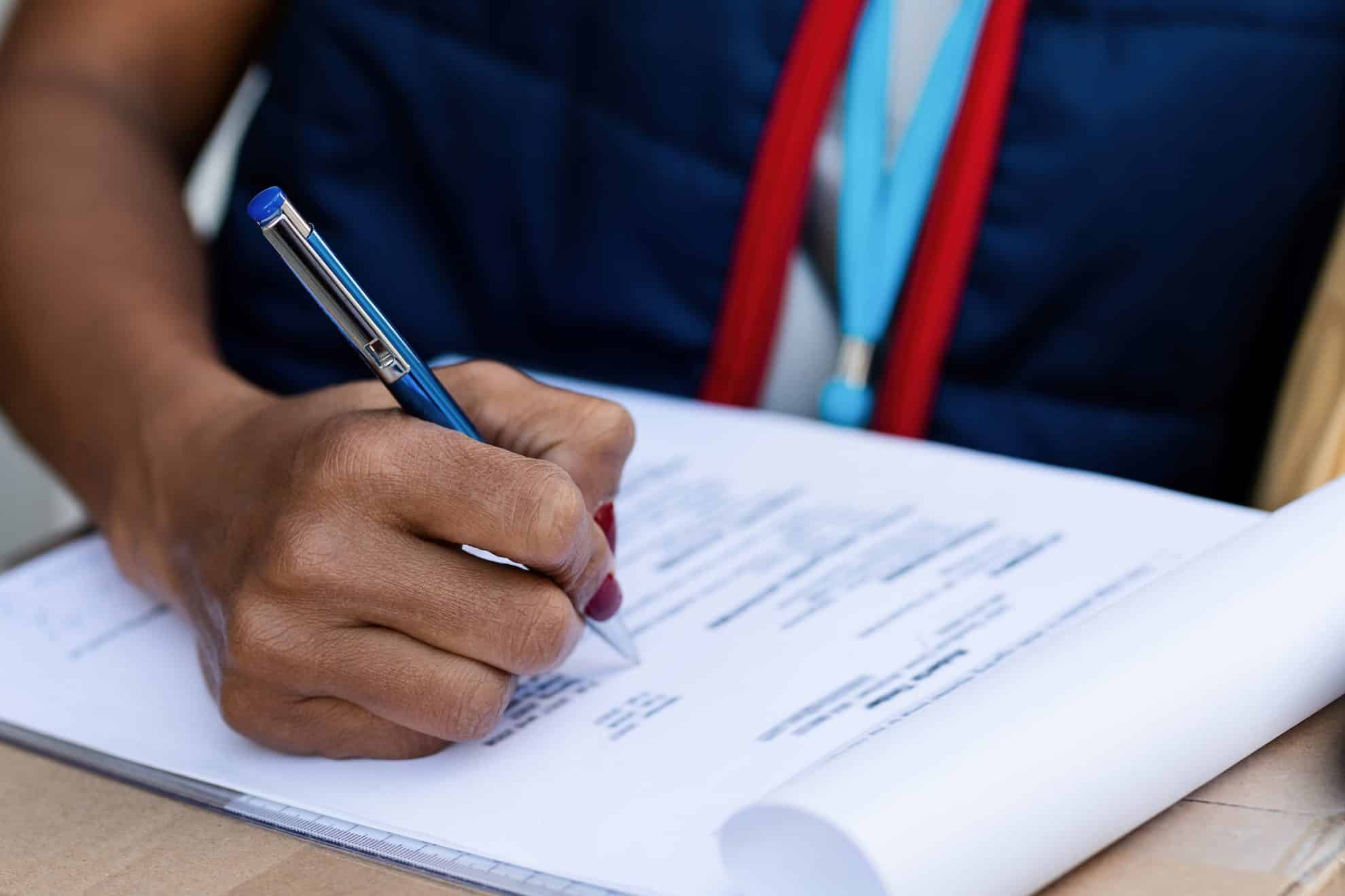 A picture of someone signing their no objection certificate in the UAE.