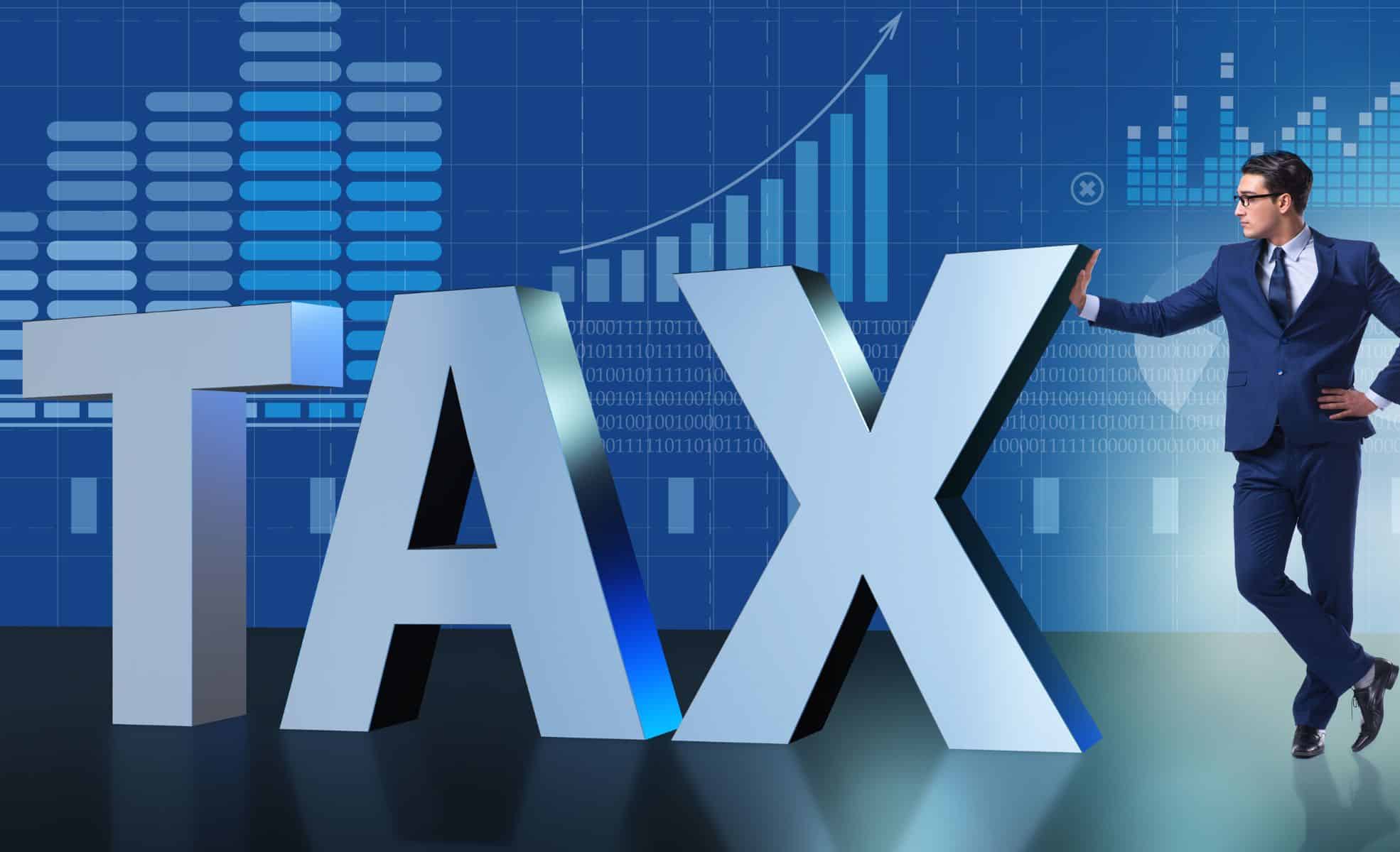 Businessman Standing Next To Tax Sign