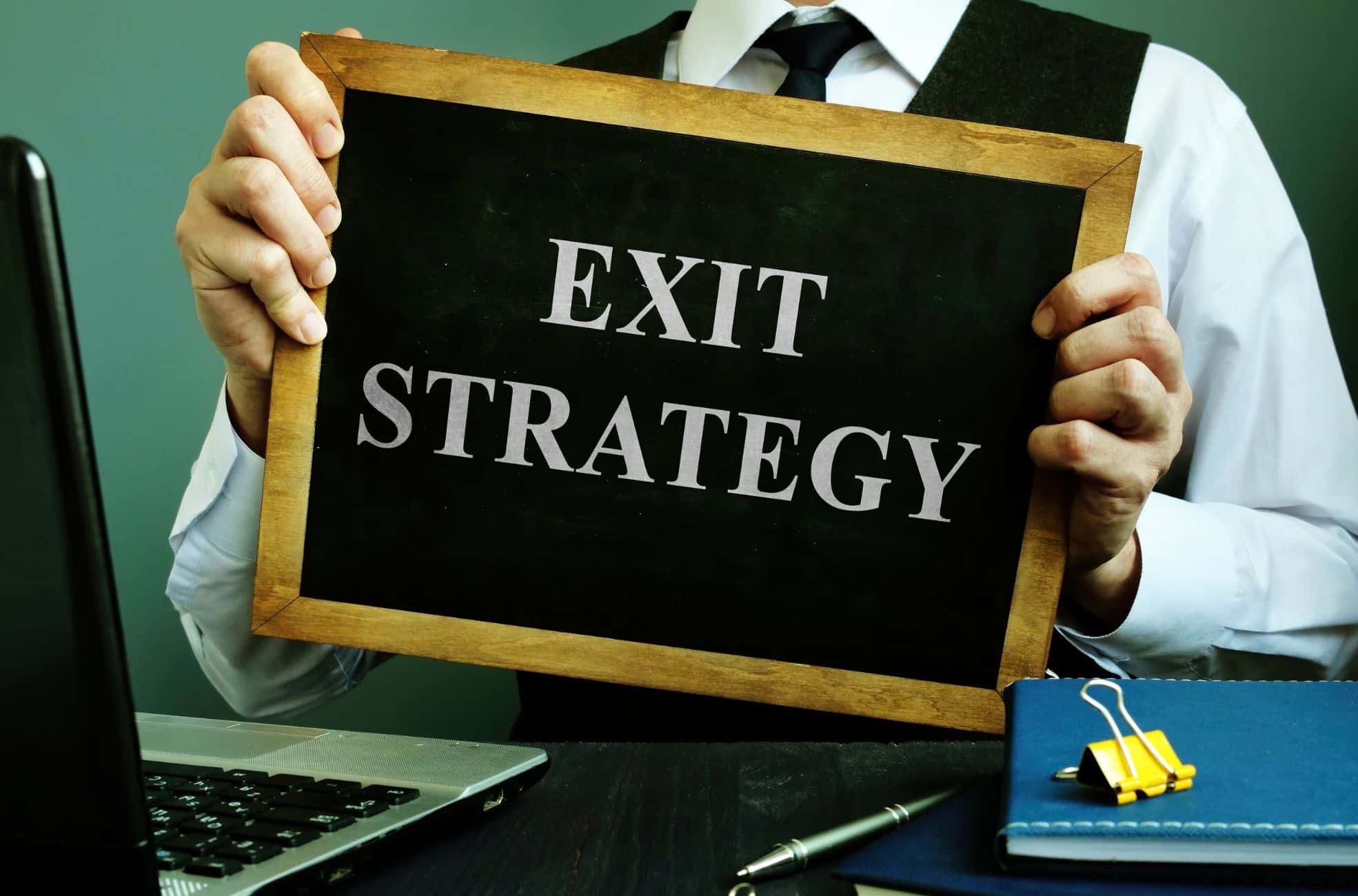 Man Holding Sign Saying "Exit Strategy"
