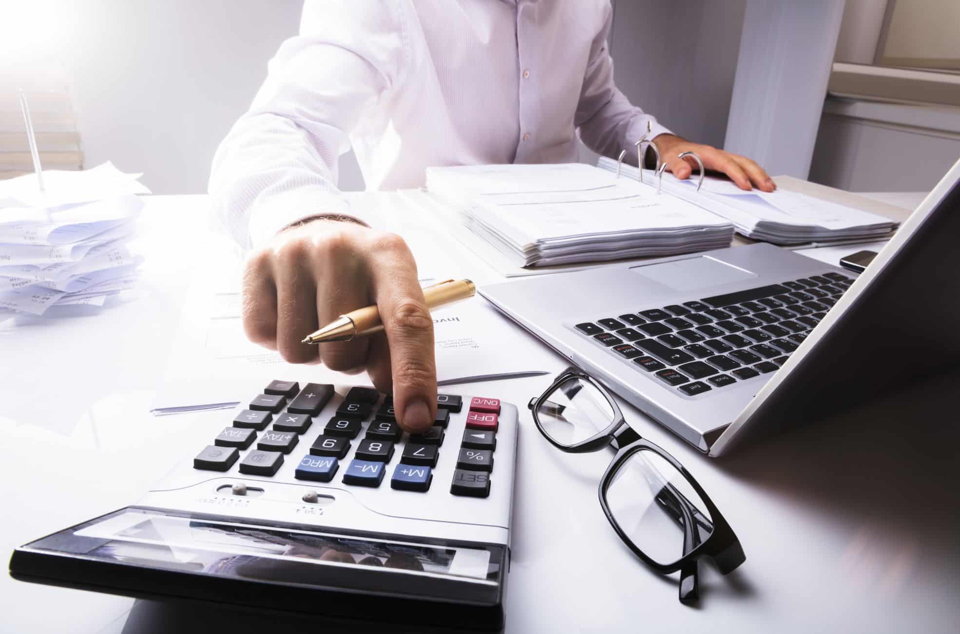 Person Working At Desk With Calculator