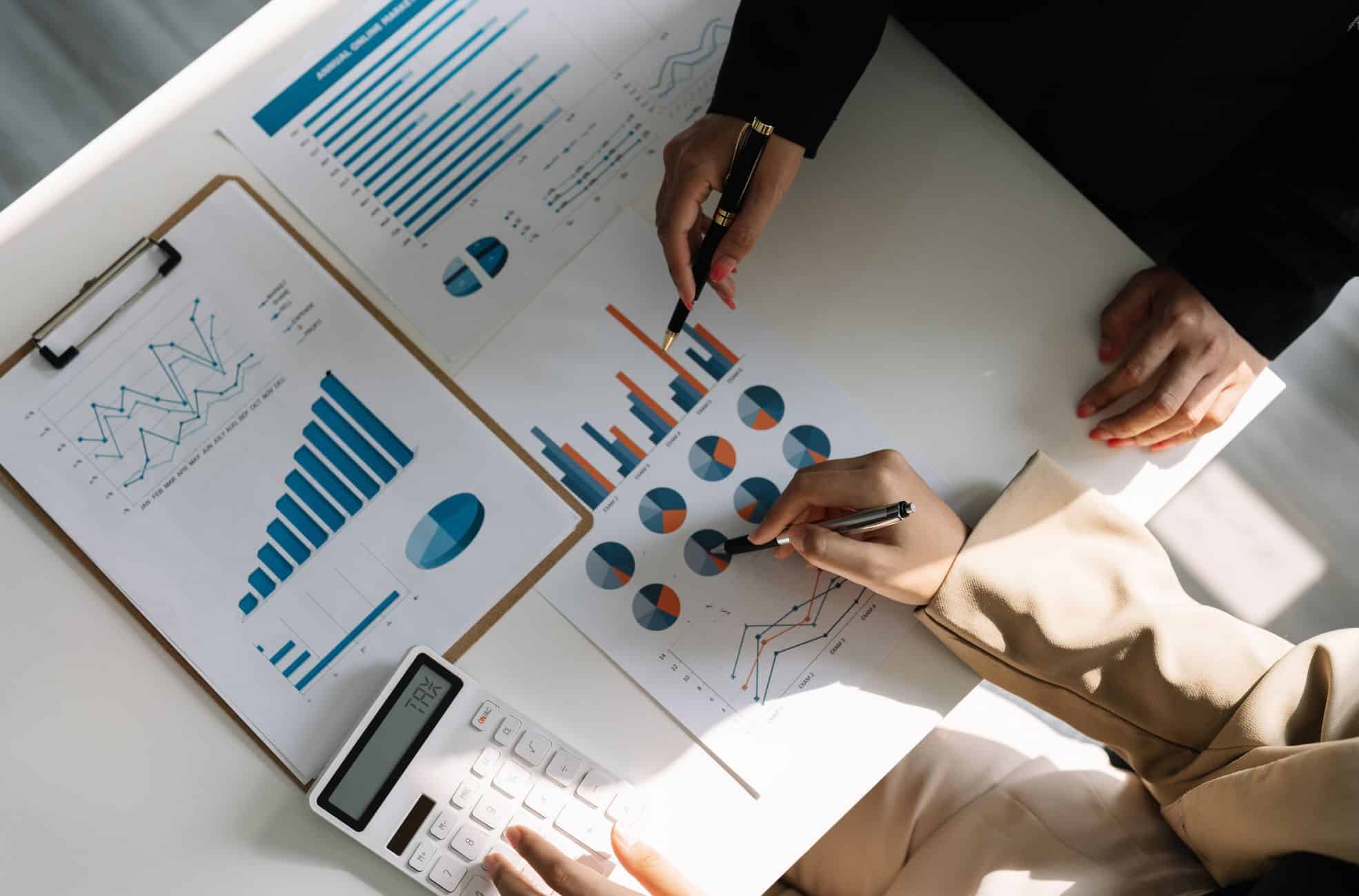 People Working On Business Expenses With Graphs