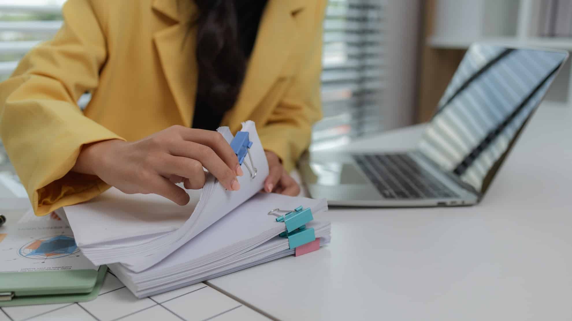 A bank teller helping business owners open a business bank account in Dubai.