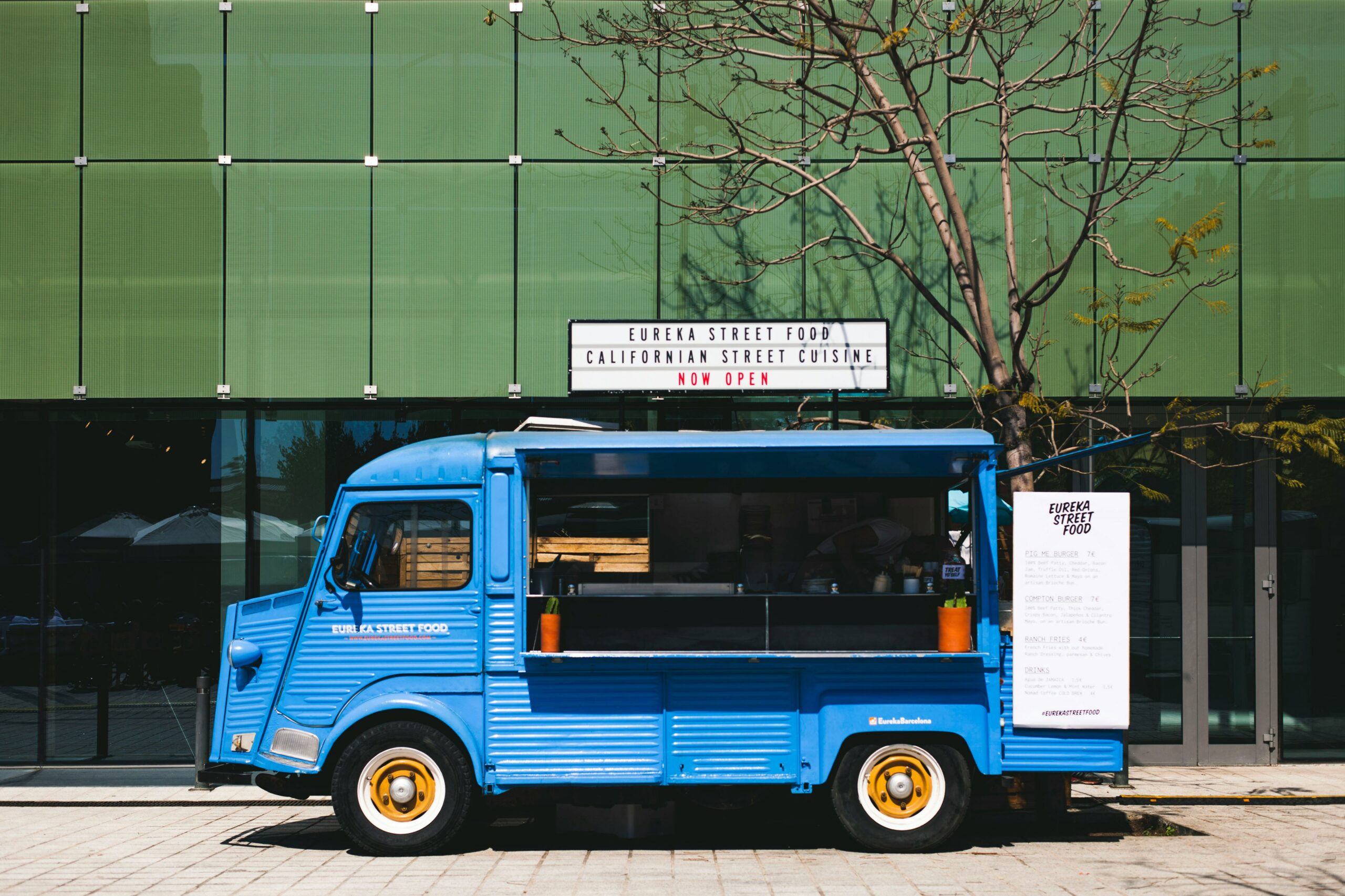 A blue food truck parked on the street in Dubai.