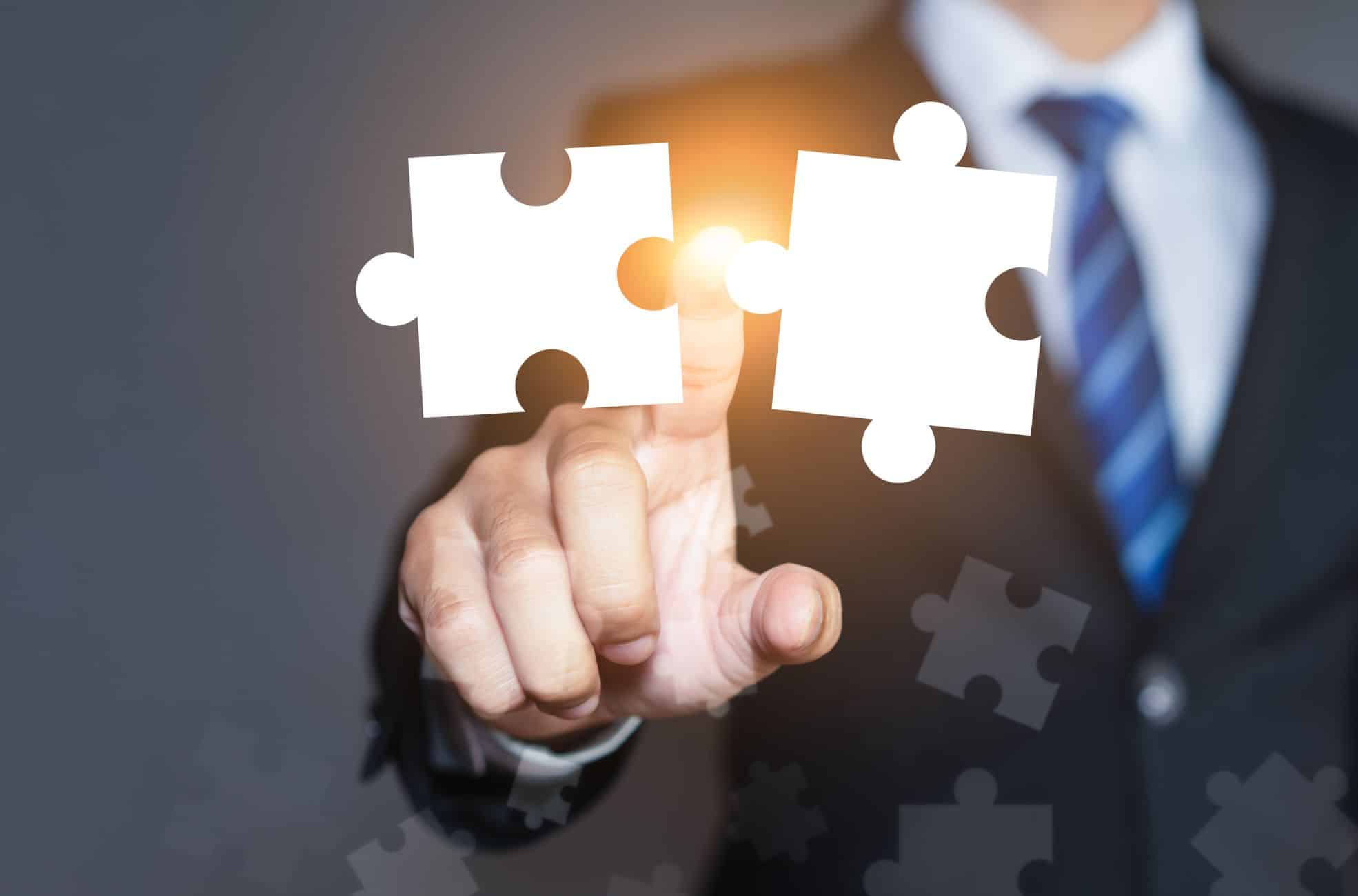 Man Pointing To Two Joint Puzzle Pieces