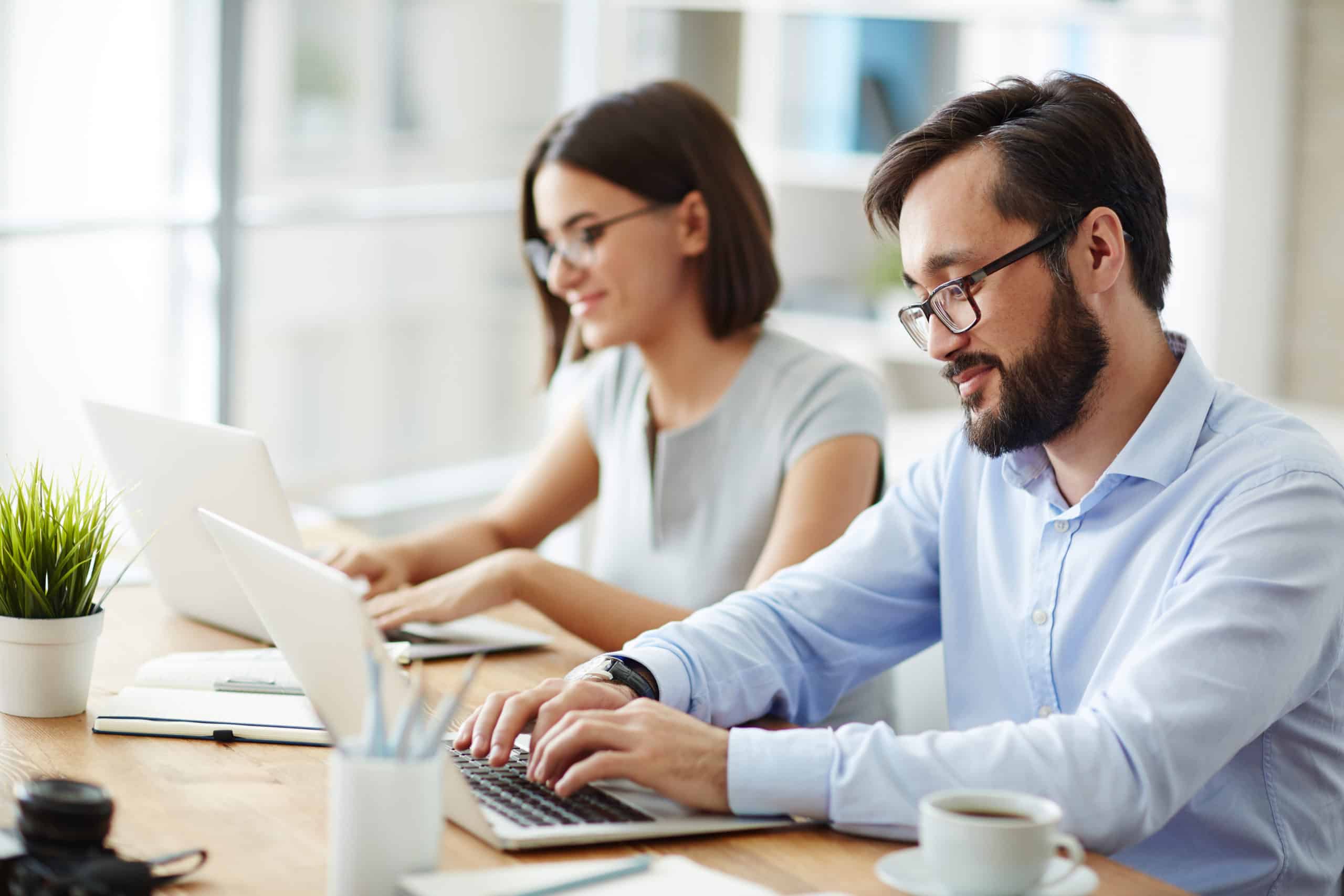 Office employees working at computers in various free zones in Dubai.