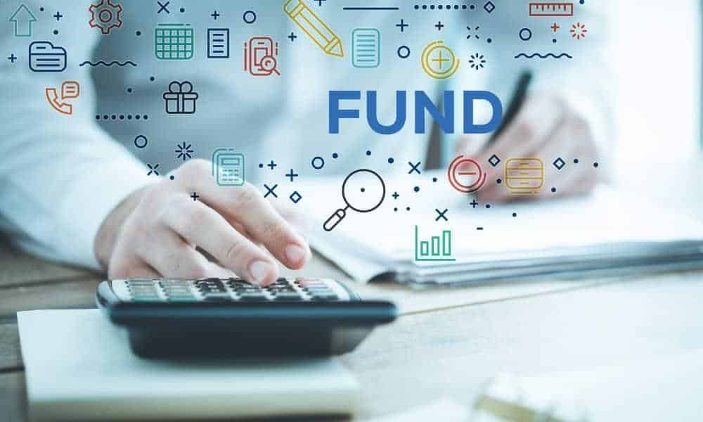 Person Working At Desk With Word "Fund" Over