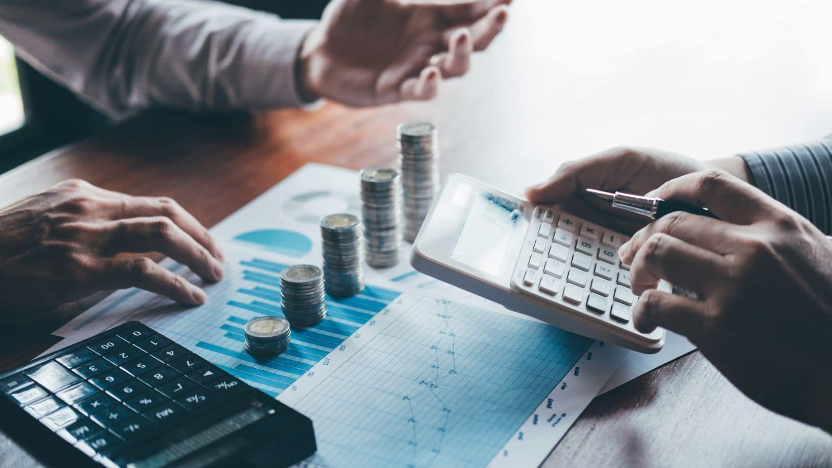 People Counting Money With Calculator